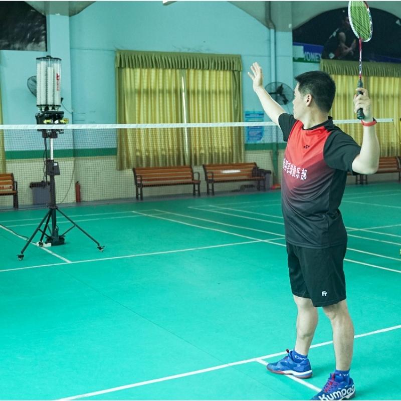 Player in red and black jersey readey to play with Siboasi b2202A automatic badminton machine